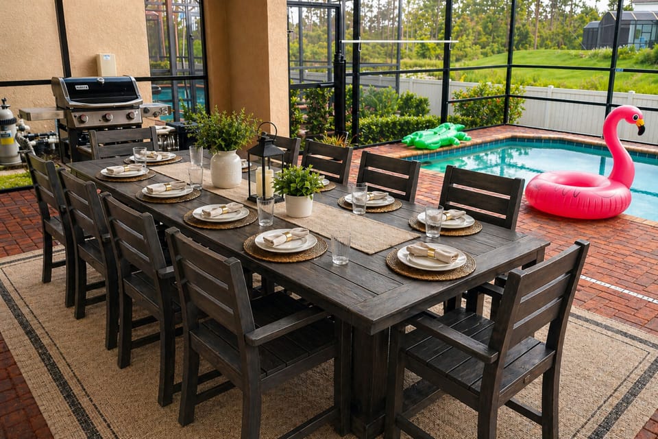 Poolside dining for 10 with BBQ, screened enclosure, child safety pool fence, and playful floats