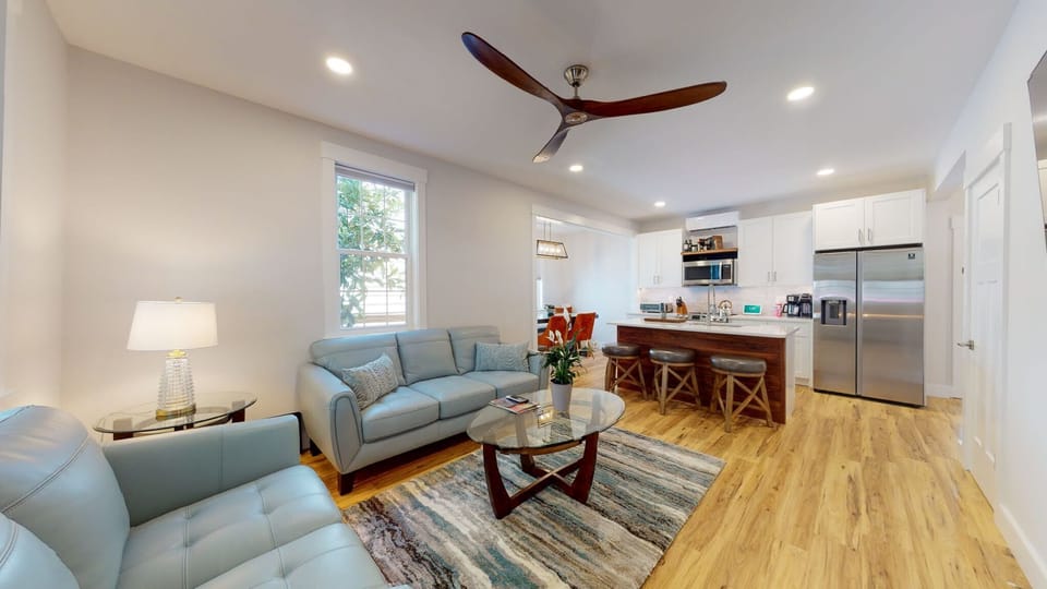 View toward kitchen showing kitchen island and propeller ceiling fan