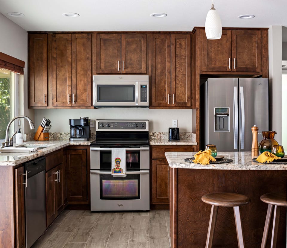 Beautiful blend of dark wood and stainless steel appliances.