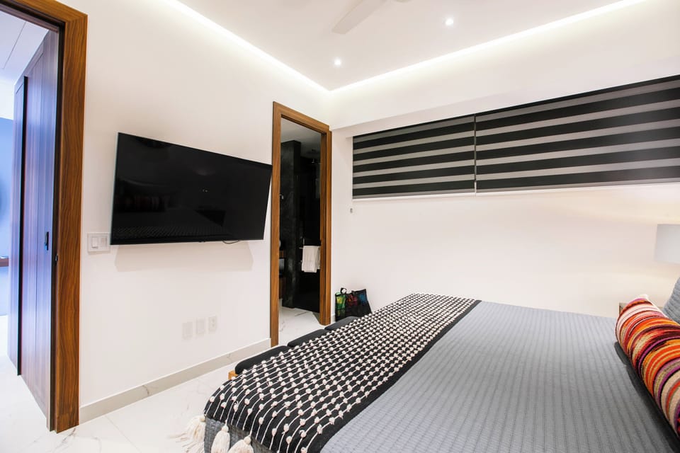 Drift off in your crisp, modern bedroom, where soft lighting sets a relaxing mood and a wall-mounted TV invites cozy nights in. Step through to your private ensuite for ultimate convenience.