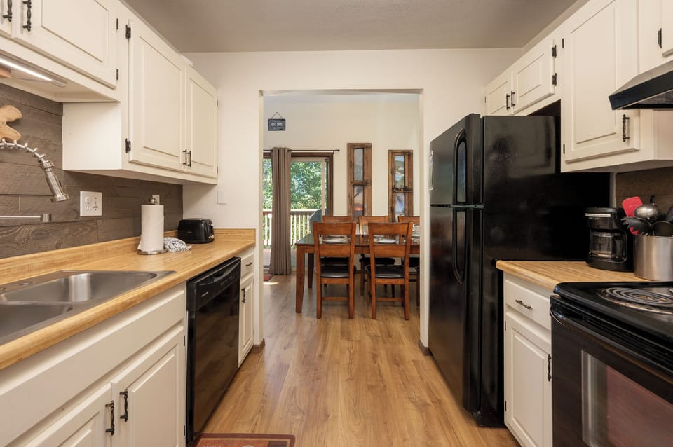 Your fully equipped galley kitchen invites culinary adventures with sleek appliances, warm wood counters, and a cozy dining nook just steps away.