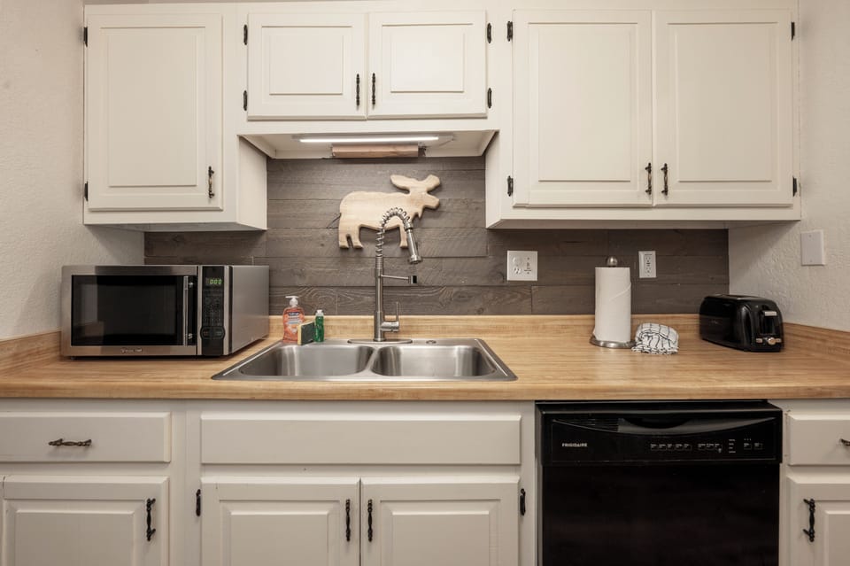 Your fully equipped kitchen features warm wood countertops, stainless steel appliances, and charming rustic touches that make cooking feel like home.