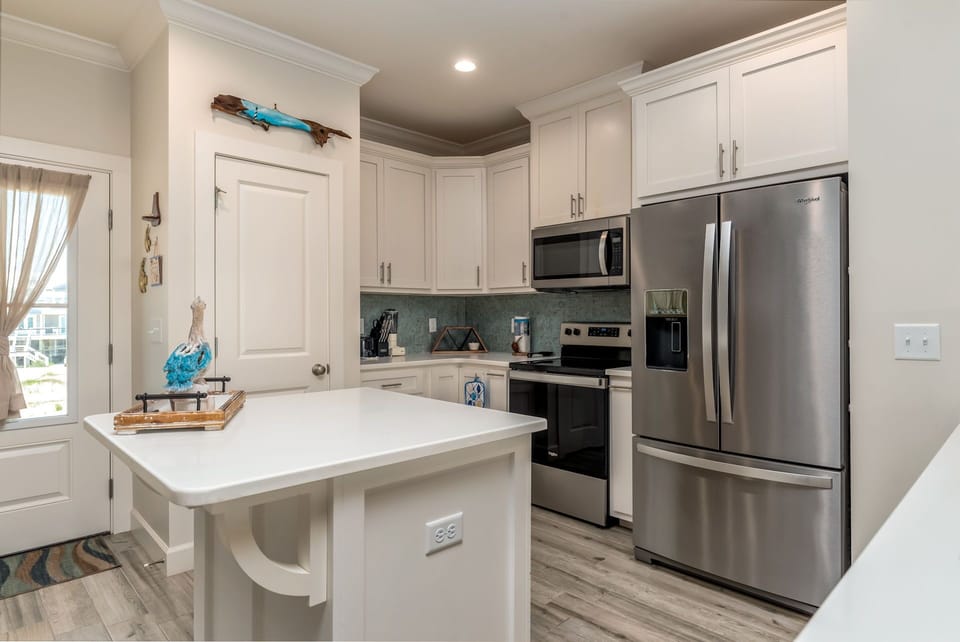 Cook your favorite meals in this bright, fully-equipped kitchen with stainless steel appliances and coastal charm.