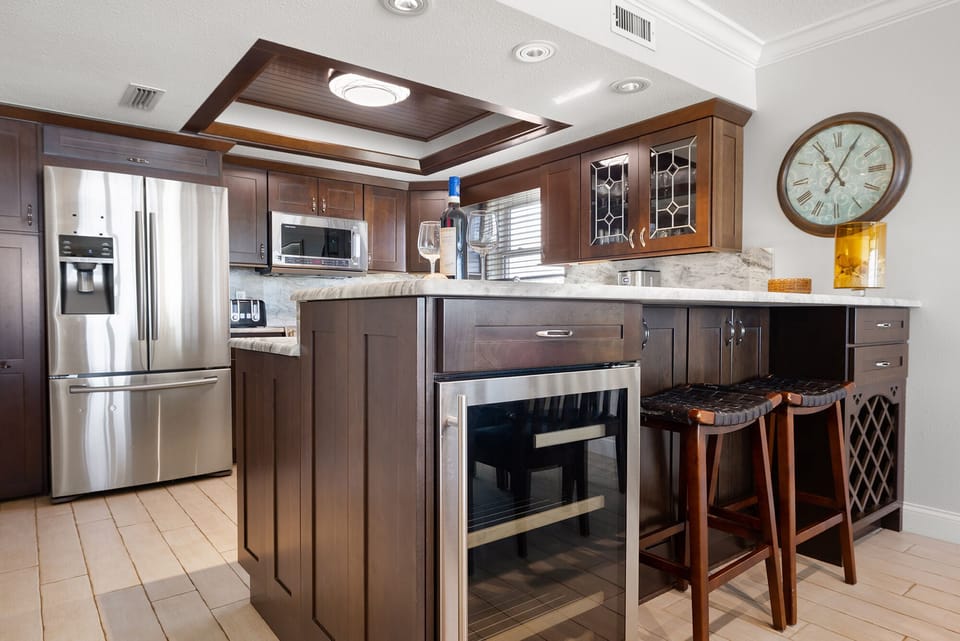 State-of-the-art kitchen bar with wine cooler, comfy bar stools, and wine rack