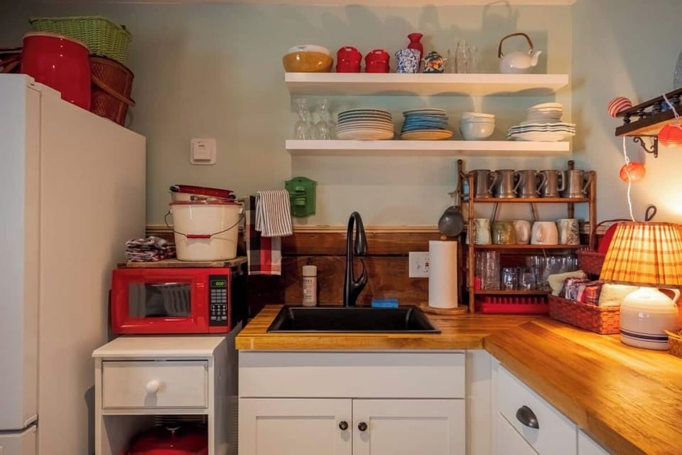 Close up of the sink and dishes. The red microwave now has a toaster oven above it not shown in this picture. 
