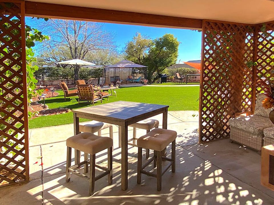 French doors in living room open to rolling grass courtyard with fire pit