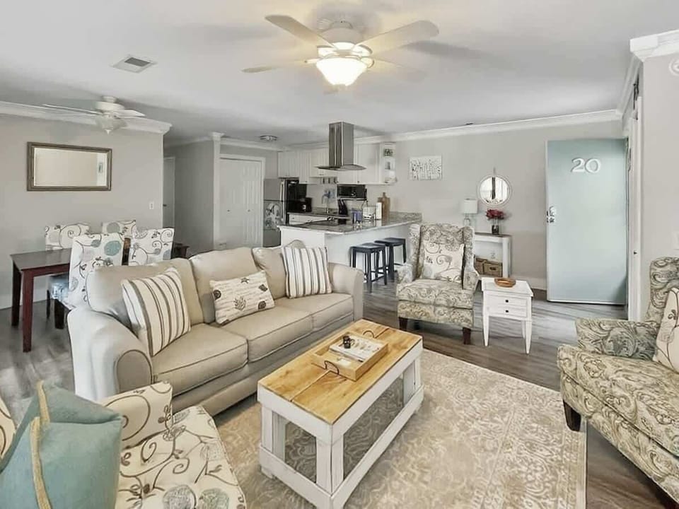The room is anchored by a rustic wood coffee table and a large area rug.