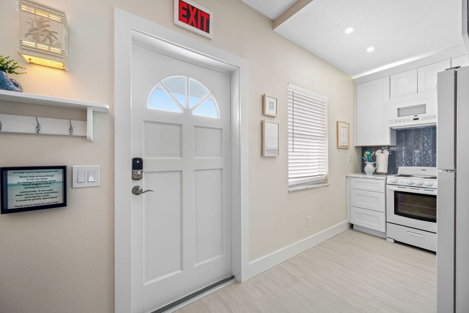 A bright and inviting entrance leading into a modern, fully-equipped kitchen with stylish finishes.
