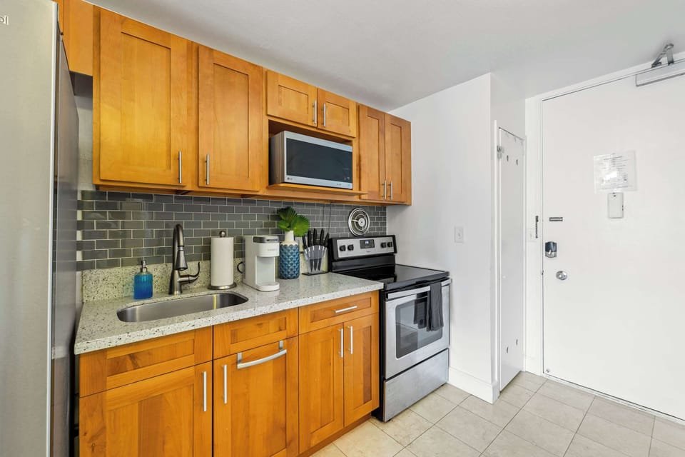A cozy wooden kitchen featuring essential appliances and stocked wit some basics needed for cooking.