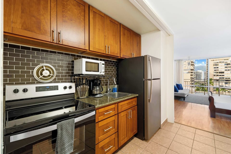 Modern kitchen with basic appliances, sleek counters, and stylish cabinetry