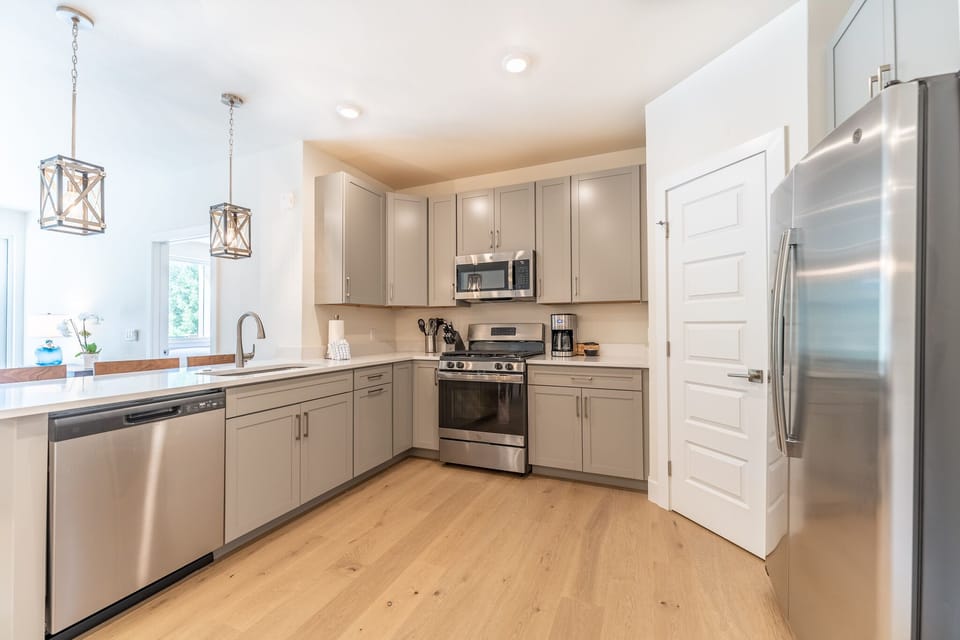 Your gourmet kitchen awaits with sleek stainless appliances, warm wood floors, and elegant pendant lighting for memorable meal prep.
