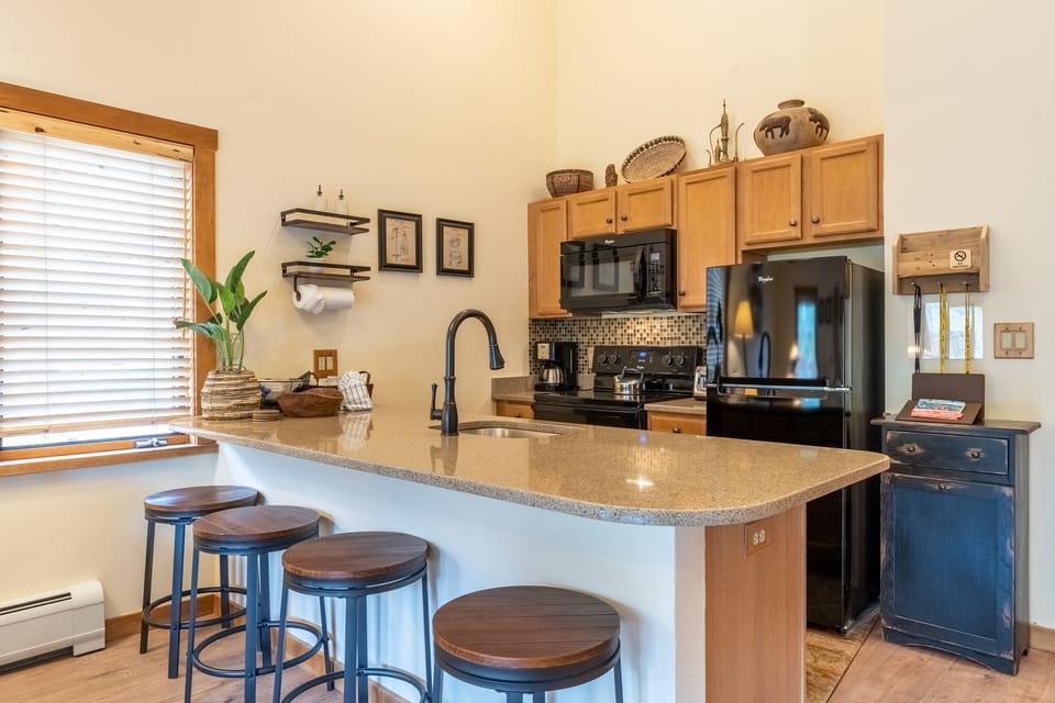 Your fully equipped kitchen awaits with granite counters, modern appliances, and a breakfast bar where you can start each morning.