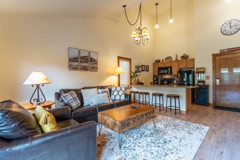 Relax in your stylish living space with plush leather seating, warm lighting, and a fully equipped kitchen perfect for memorable evenings.