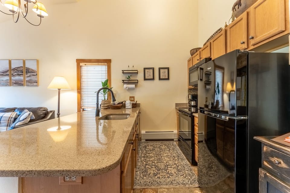 Your fully equipped kitchen awaits with granite counters, modern appliances, and warm wood cabinets perfect for preparing memorable meals during your stay.
