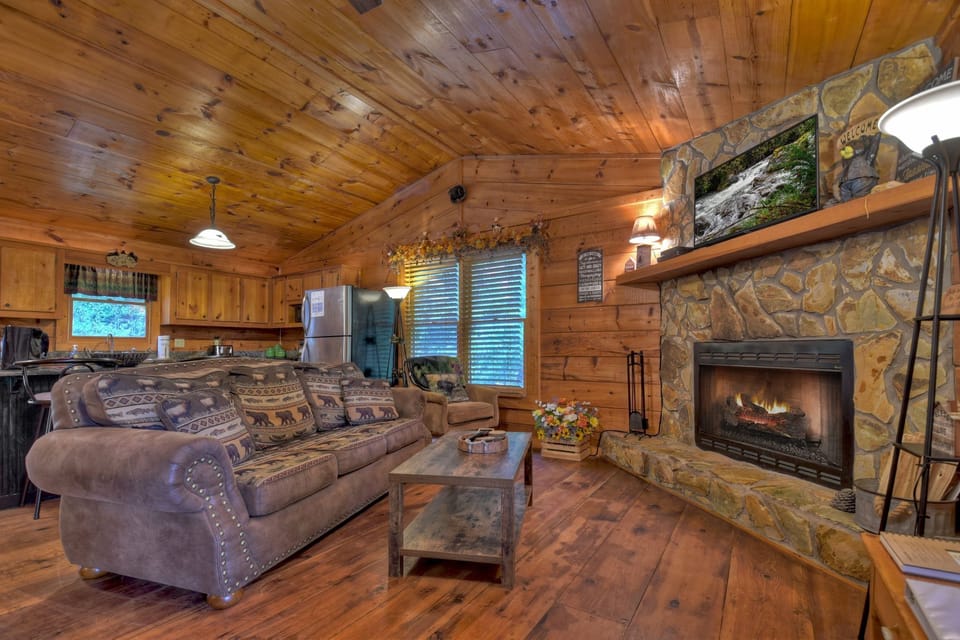 Cozy living room with fireplace, comfy couch, and rustic wooden decor.