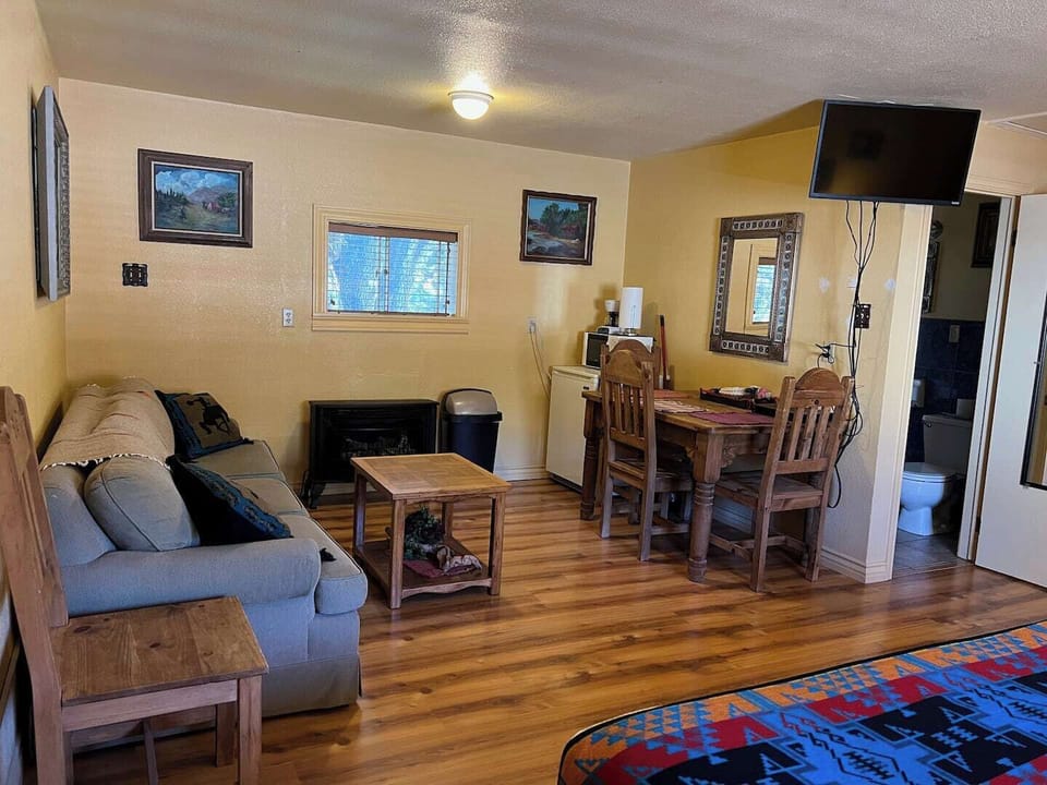 Living area includes a small dining table, mini-fridge, microwave, coffee maker, and TV with Dish TV service.