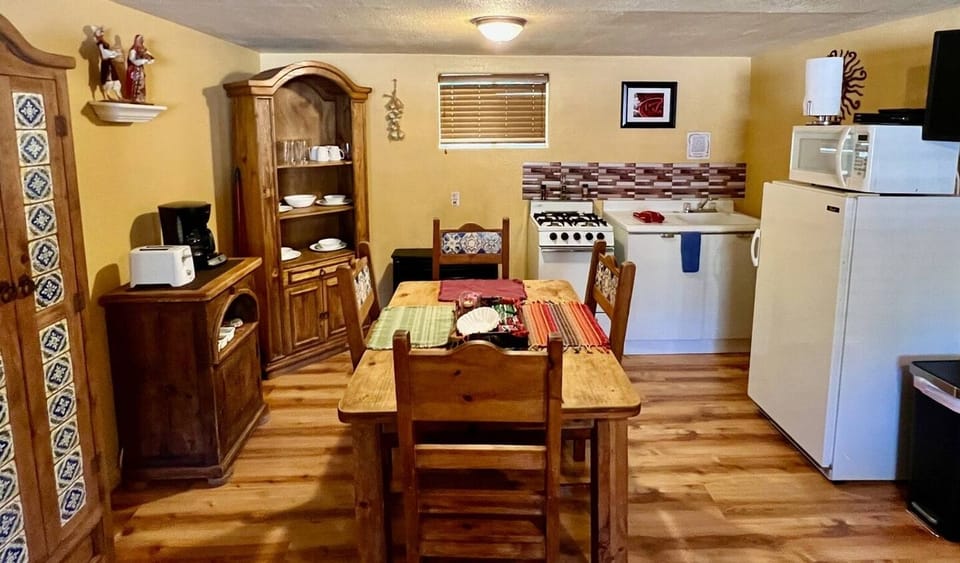 Dining area and small kitchen stocked with cooking amenities. 