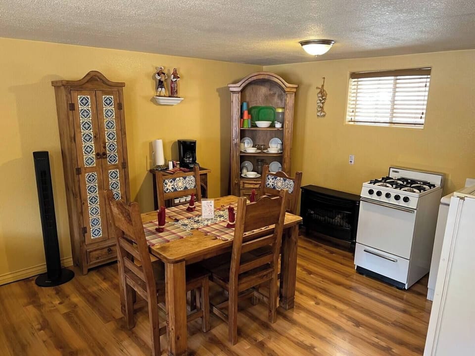 Dining area and small kitchen stocked with cooking amenities. 