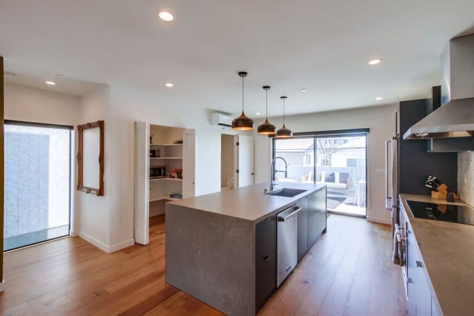 Located on the second floor, this kitchen boasts state-of-the-art appliances, custom cabinetry with soft close technology, waterfall counter top, 4 bar top seats, split system AC, and a southeast facing balcony.