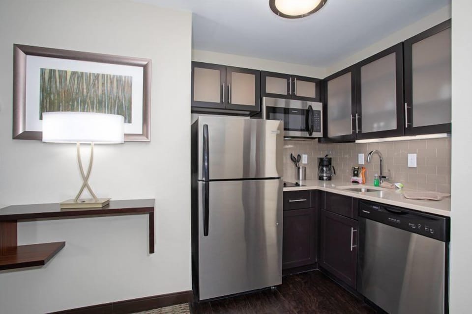 Studio layout with queen bed, kitchenette, and flat-screen TV in a single open room