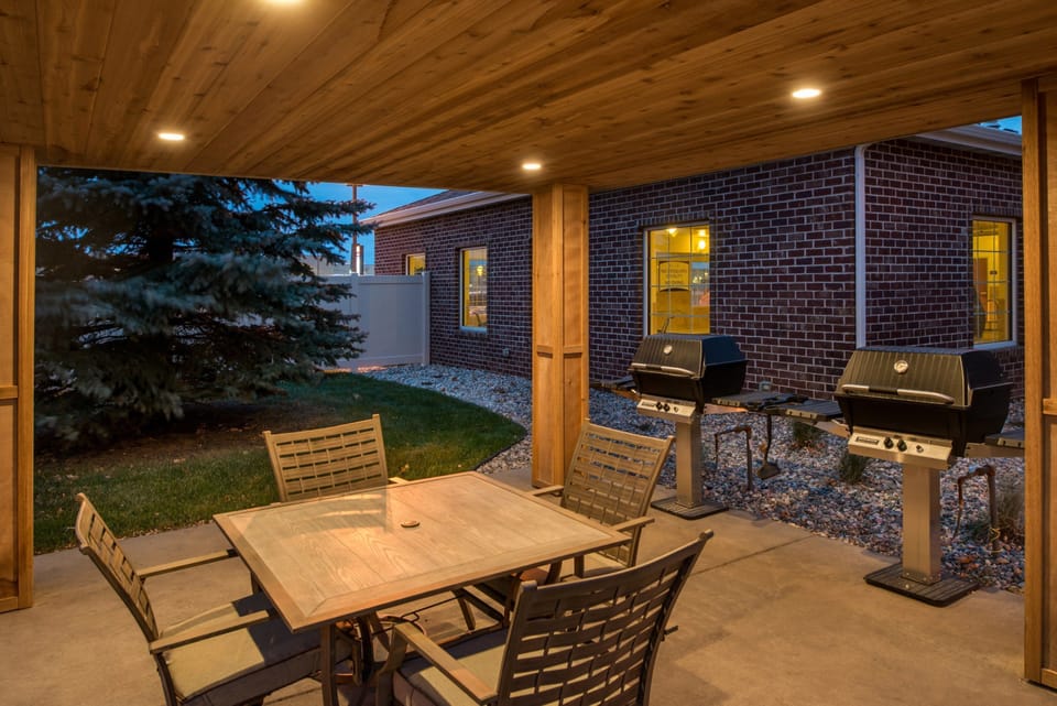 Outdoor grilling area featuring barbecue grills and a dining table.