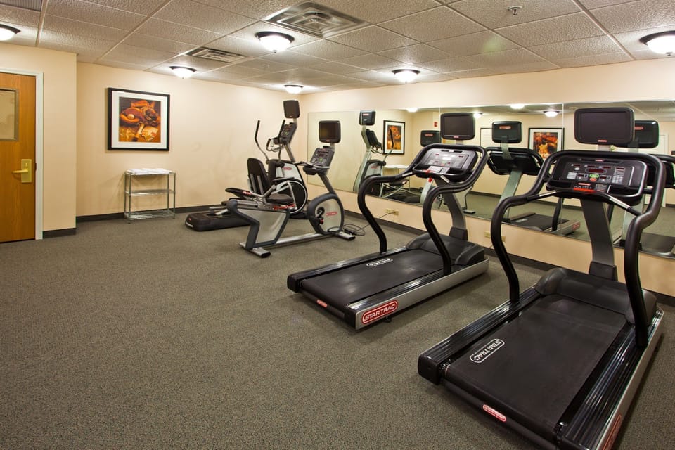 Keep up with your fitness routine in a well-equipped gym that blends comfort with functionality.