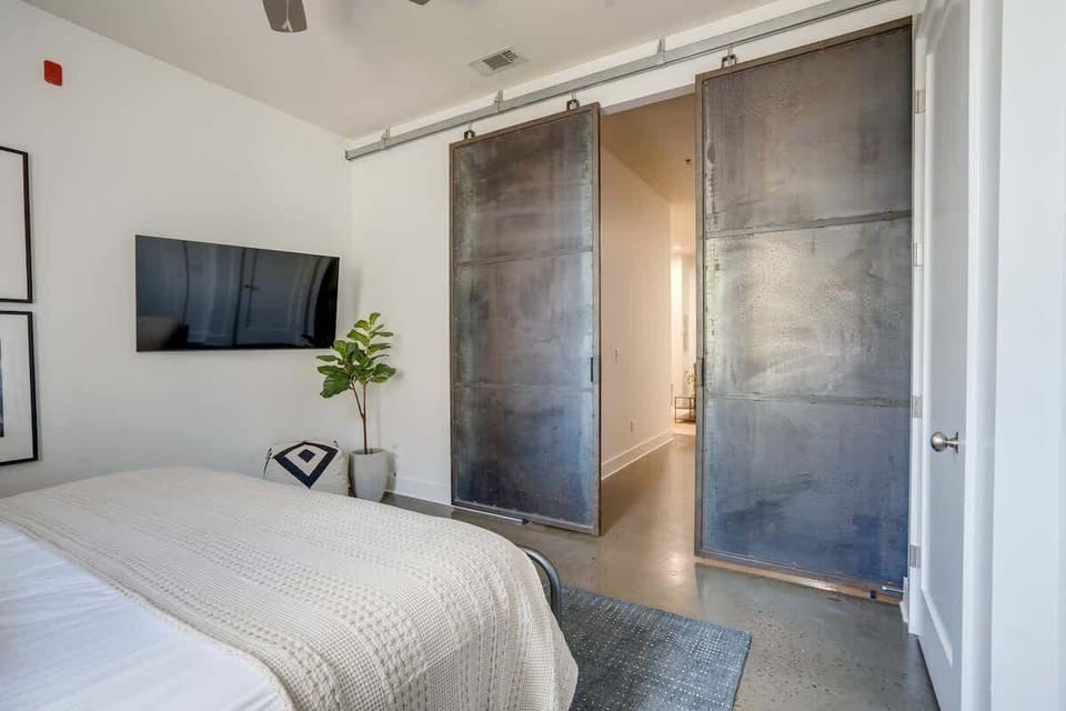 Primary bedroom with King-size bed, beautiful furnishings, and flat-screen TV. Full fold-out bed located in the closet.