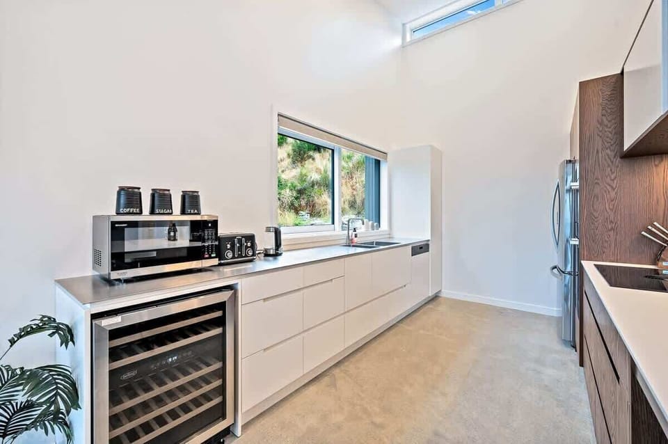 The modern kitchen is fully equipped with high-end appliances, including a wine fridge and coffee machine, offering seamless indoor-outdoor flow to the deck with stunning views of the lake and mountains.
Indulgence in luxury accommodation, NZ