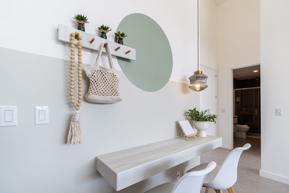 Your entry space welcomes you with coastal charm—organic textures, soothing greenery, and a floating desk ready for you to plan your next adventure or unwind with a morning coffee.