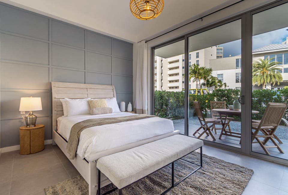 Wake up in this bright, beautifully styled bedroom where coastal elegance meets total comfort. Your private patio awaits just beyond the sliding doors, perfect for morning coffee with views of tropical greenery.
