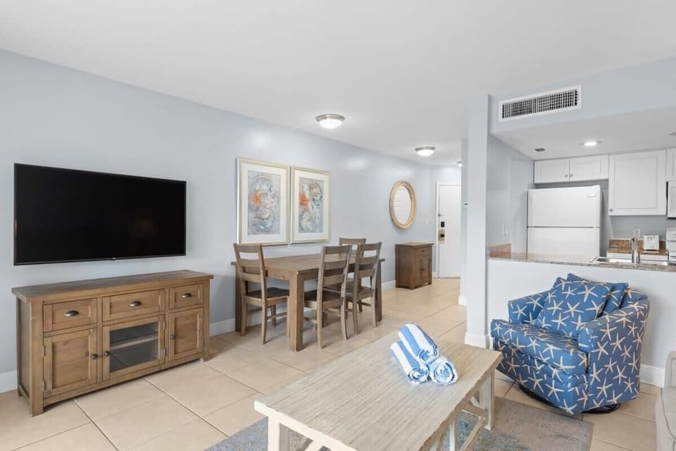 Flat screen TV, dining table for up to four guests, and full sized kitchen