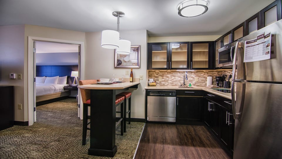 Bright full kitchen with modern appliances and casual bar seating.