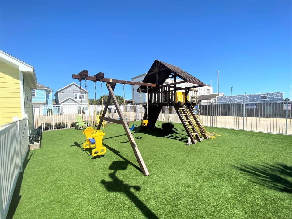 Spacious community playground with swings, slides, and safe turf for kids.