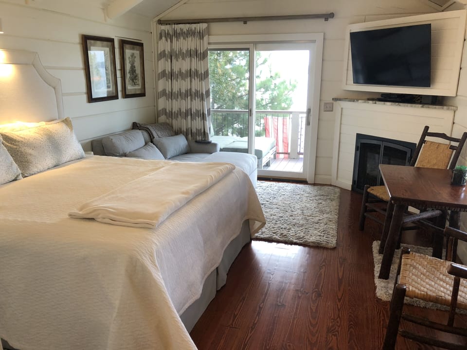 Living area w 60" loveseat and king size bed, table for 2, fireplace (seasonal)