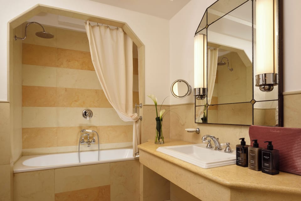 Deluxe Room, 1 King Bed | Bathroom | Combined shower/tub, rainfall showerhead, designer toiletries