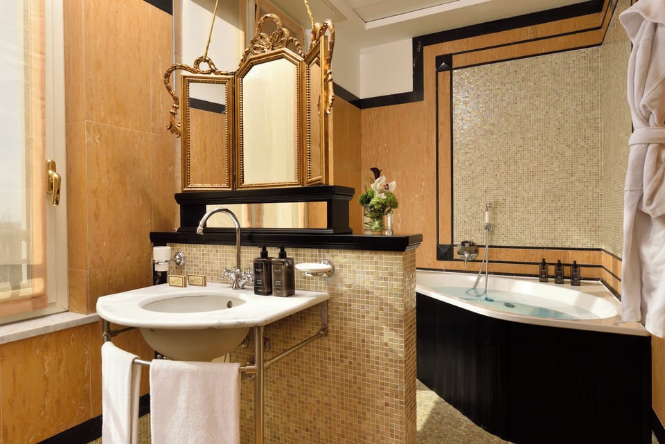 Suite, 1 King Bed (Savoia) | Bathroom | Combined shower/tub, rainfall showerhead, designer toiletries