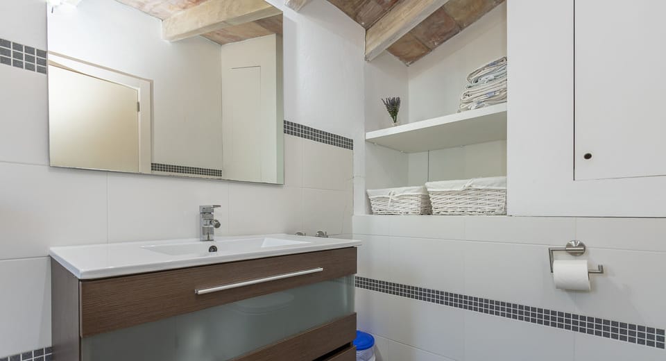 Functional bathroom with modern sink and shelving.