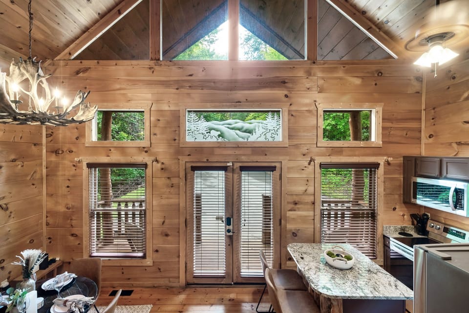 Tall windows provide natural lighting in the kitchen/dining area.