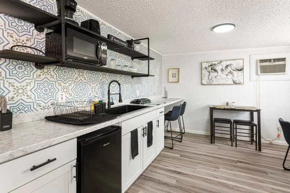 kitchen with cabinets, small two-place stove, fryer and slow cooker with microwave oven