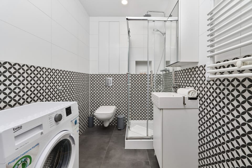 The bathroom's contemporary design includes fresh towels and a hairdryer. 