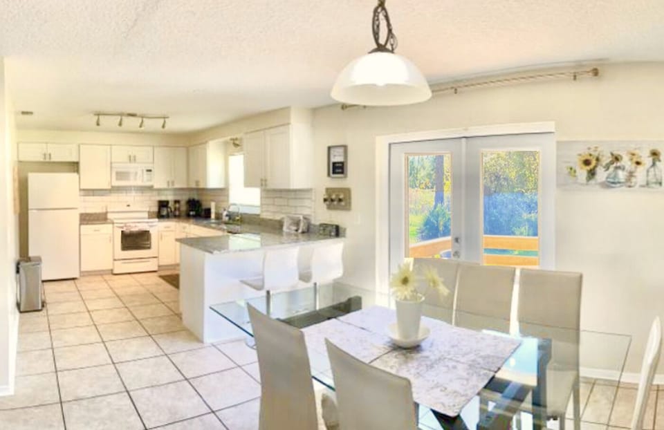 Crisp and sunny kitchen with a nice table overlooking pure green outside
