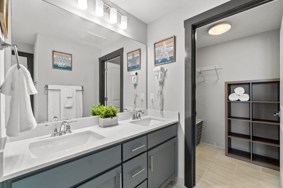 Master bathroom with double vanities, walk-in closet and walk-in shower