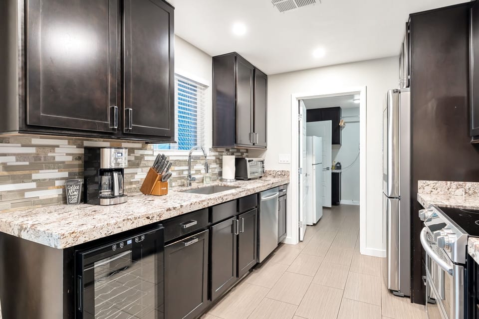 Fully stocked kitchen with coffee maker, toaster oven, knife set, wine fridge.