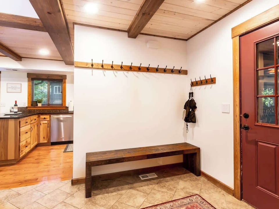 Entryway mudroom with plenty of space for hanging snow or hiking gear, with boot trays and umbrellas. 