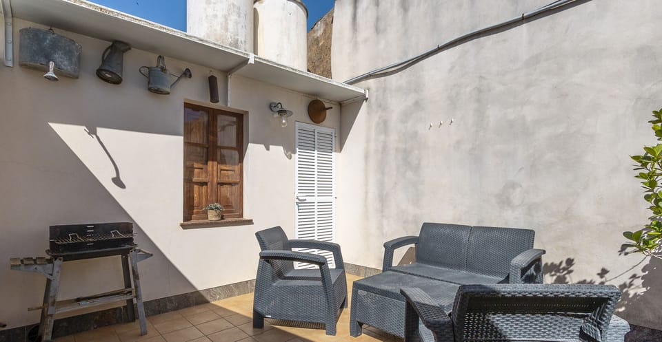 Cozy private terrace with outdoor seating area and barbecue, perfect for relaxing and enjoying the warm weather.