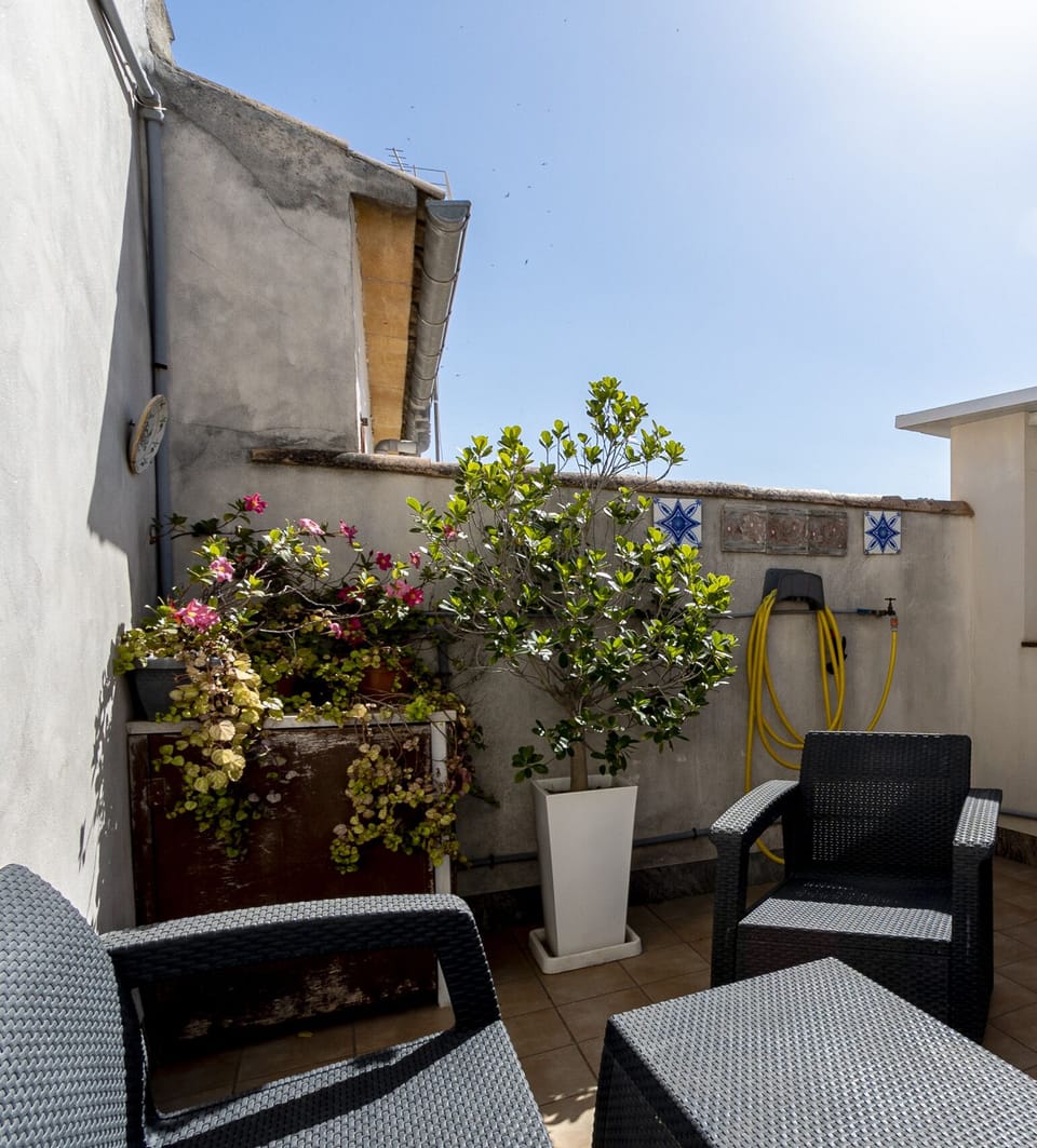 Cozy outdoor terrace with seating area, decorative plants and open views, perfect for enjoying the Mediterranean weather.