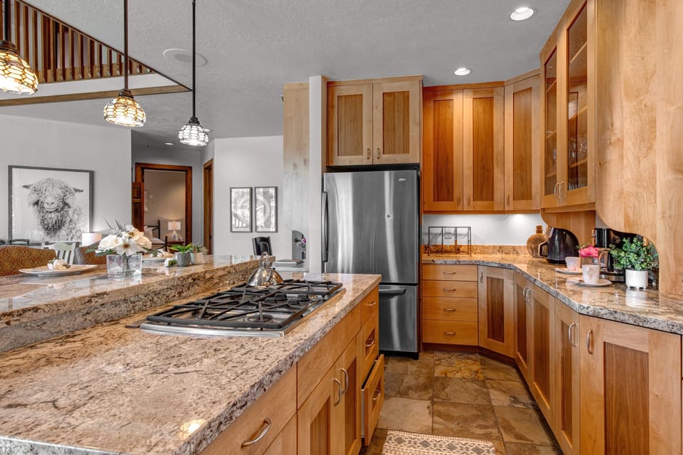 Fully Equipped Kitchen with gorgeous stone countertops, stainless steel appliances, private deck access, and island seating for 3