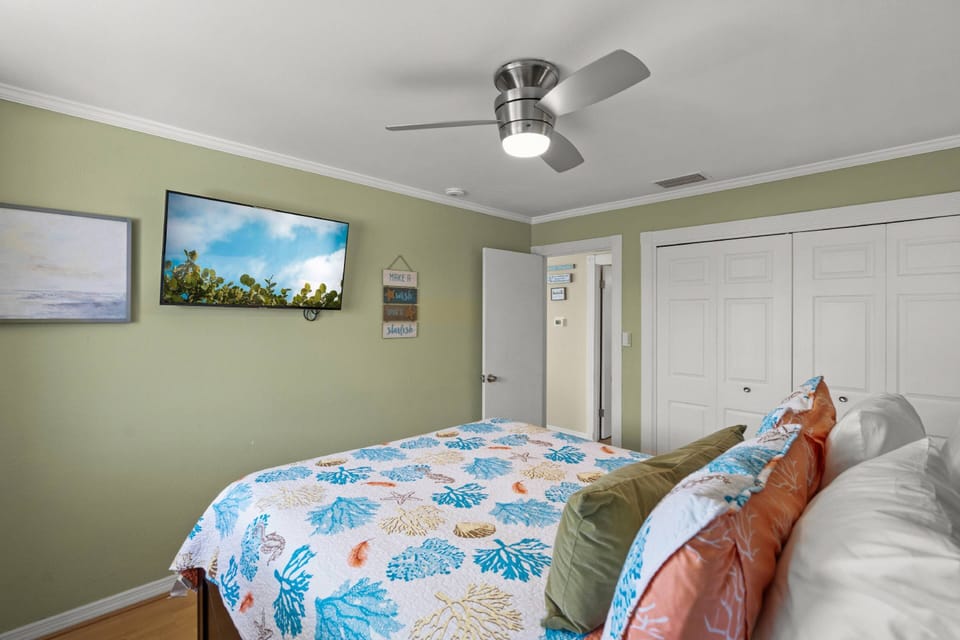 The bedroom features a wall mounted TV, perfect for binge watching after a day at the beach.