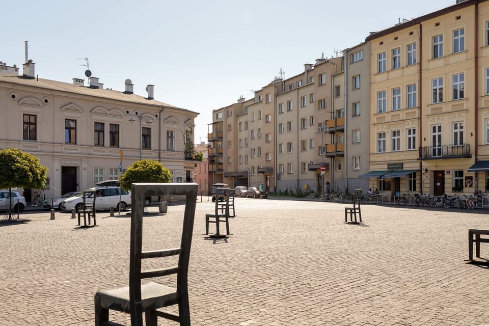 A nearby open square or plaza, featuring seating and traditional architecture in the background.

