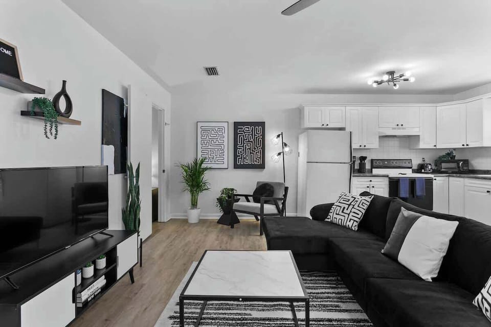 Kick back in style – our spacious black-and-white living room features a 65-inch smart TV for epic movie nights